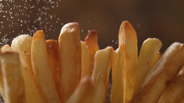 Adding salt on french fries. Shot with high speed camera, phantom flex 4K. Slow Motion.