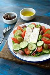 Traditional Greek salad. Light and healthy food. Blue  food background
