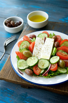 Traditional Greek salad. Light and healthy food. Blue  food background
