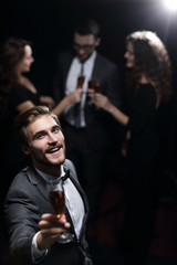 stylish young man standing with a glass of champagne.