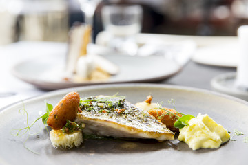 Plate with tasty fish steak on grey background