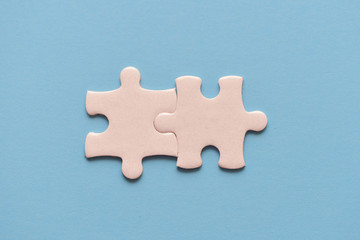 Obraz premium Two white details of puzzle on blue background