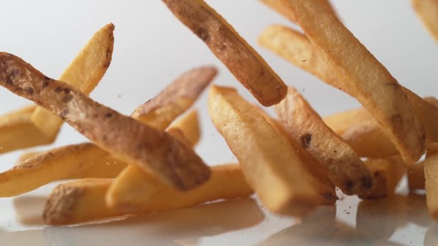 French fries falling on white surface. Shot with high speed camera, phantom flex 4K. Slow Motion.