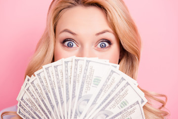 Close up portrait of shocked surprised girl peeking out fan of much money with wide open eyes...