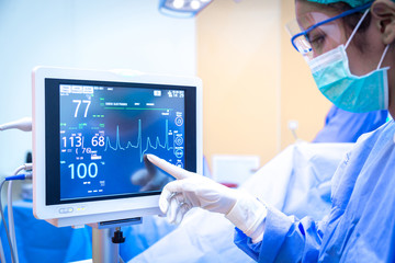 Female surgeon using monitor in operating room.