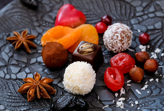 Truffles and dried fruits on a black clay plate