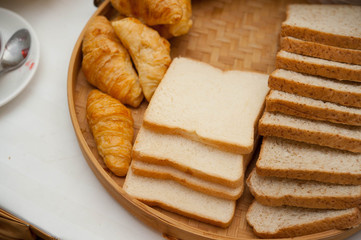 Sliced ​​bread and Croissant lay on a wooden tray,whole wheat breads lay on wooden tray