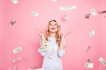 Portrait of cheerful glad girl enjoying shower from 100, hundred dollars, flying money, gesturing...
