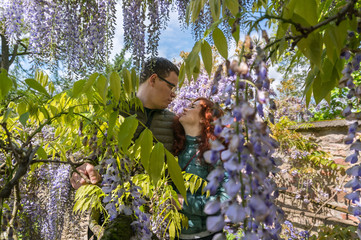 Young couple among wisteria trees