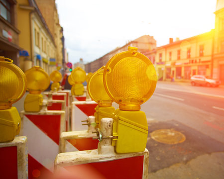Yellow road work flashers close up with sunset sun and awesome lens flares