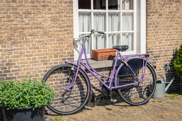 Fototapeta na wymiar Purple ladies bike against a brick wall