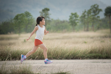 Little girl running running on the road in the countryside, sports, healthy lifestyle