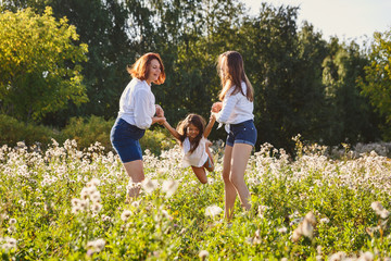 Fototapeta premium happy family playing with baby on the lawn in summer