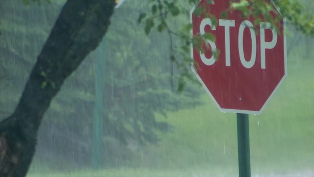 Stop sign in pouring rain thunderstorm