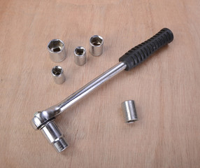 various professional metalwork tools on a background of beech wood