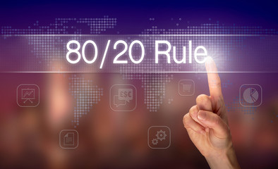 A hand selecting a 80 / 20 Rule business concept on a clear screen with a colorful blurred...