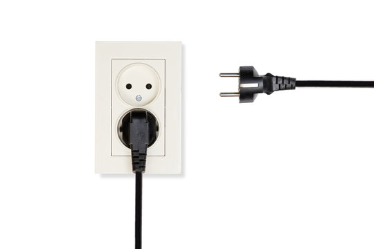 Closeup beige double electrical outlet and two black cables with plugs isolated on a white.