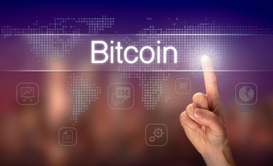 Naklejka premium A hand selecting a Bitcoin business concept on a clear screen with a colorful blurred background.