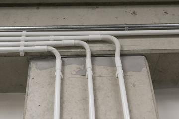 Plastic electrification tubes on the wall with a bend.