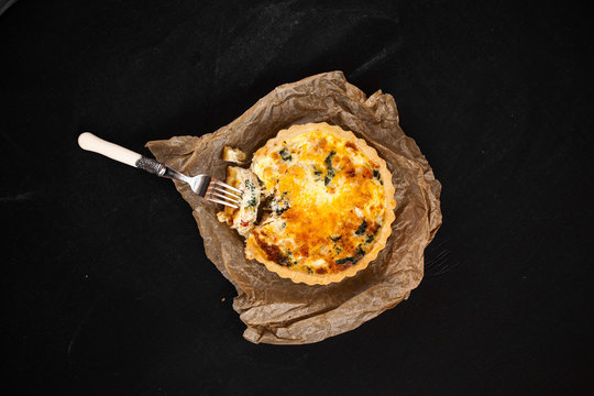 crushed kish with fork on paper and fabric  