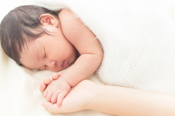 hand of a newborn baby in the hand of a parent dad