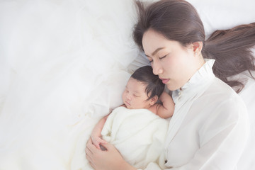 happy mother with baby in bed