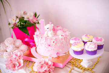 A lovely delicious candy bar in pink and gold colors for a little princess on her 1st birthday. Beautifully decorated children's party with balloons flowers and sweets