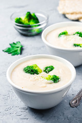 Garlic, parsnip white bean broccoli soup puree in a bowl on blue concrete background. Selective focus, space for text. 