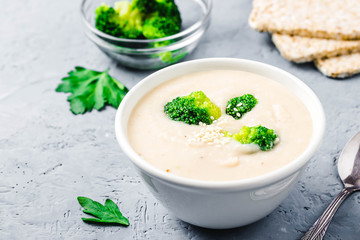 Creamy white bean broccoli soup puree in a bowl on blue concrete background. Selective focus, space for text. 