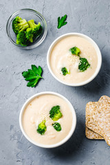 Creamy white bean broccoli soup puree in a bowl on blue concrete background. Top view, space for text. 