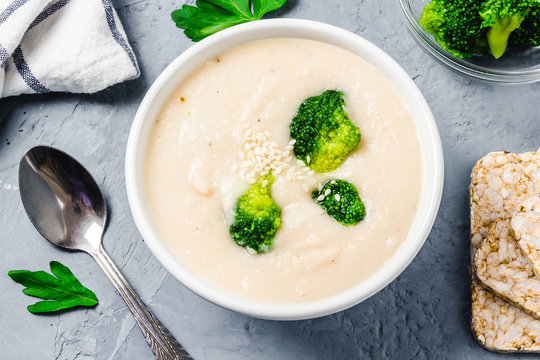 Tuscan White Bean Broccoli Soup Puree In A Bowl On Blue Concrete Background. Top View, Space For Text. 