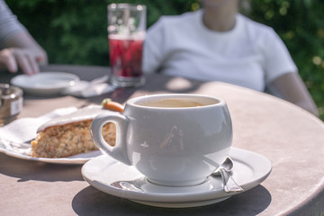Weiße dicke Kaffeetasse auf Gartentisch