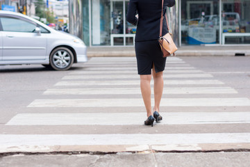 Business woman walking across the crosswalk