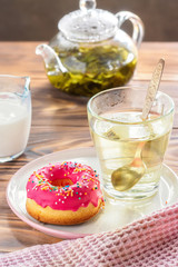 Cup of hot green tea beverages with donut glazed
