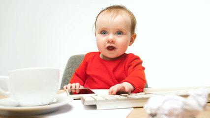 Happy child baby girl toddler sitting with keyboard of computer isolated on a white background