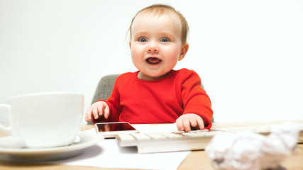 Happy child baby girl toddler sitting with keyboard of computer isolated on a white background
