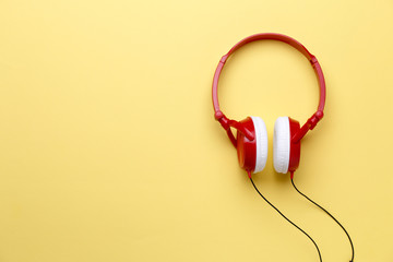 Photo of red with white headphones for music on clean yellow background