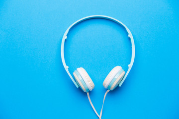Photo of white headphones on blue background