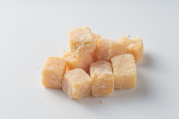 Parmesan cheese pieces on white background. Top view.