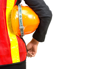 Business woman wearing orange shirt standing safely holding a helmet in an industrial safe.