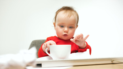 Happy child baby girl toddler sitting with keyboard of computer isolated on a white background