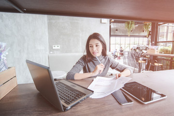 Young pretty joyful brunette woman meditating on table surround work stuff and flying papers....
