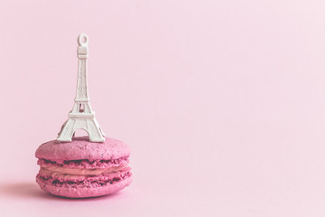 Macaron biscuit and Eiffel Tower on pastel pink background.