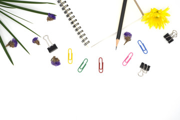 top view book, pencil for note isolated on white background with colorful paper clip, black paper clip decorate by chrysanthemum, yellow and purple flower, green leave. Desk office concept, copy space