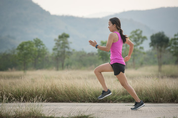 Young lady running on a rural road during sunset, sports, healthy lifestyle