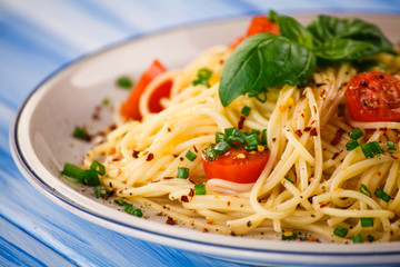 Pasta with vegetables on wooden table