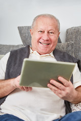 Älterer Mann mit Tablet freut sich