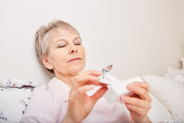 Kranke Seniorin mit Tablettenspender