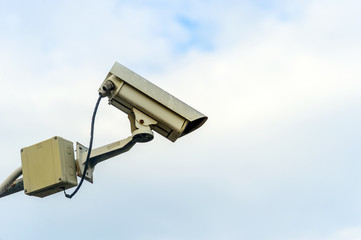 closeup CCTV security camera with soft-focus and over light in the background