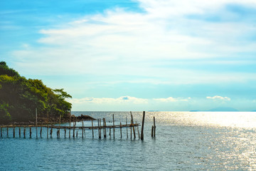 Fototapeta na wymiar Vacation time concept, A view of old wooden bridge in the sea and blue sky on background